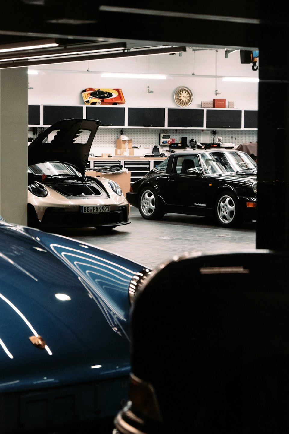 Sports cars parked inside an organized automotive workshop.